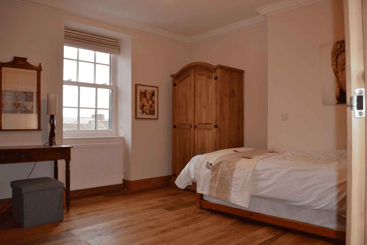 Spacious bedroom with wooden furniture and natural light