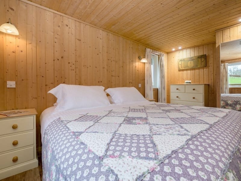 Cozy wooden cabin bedroom with quilted bedspread