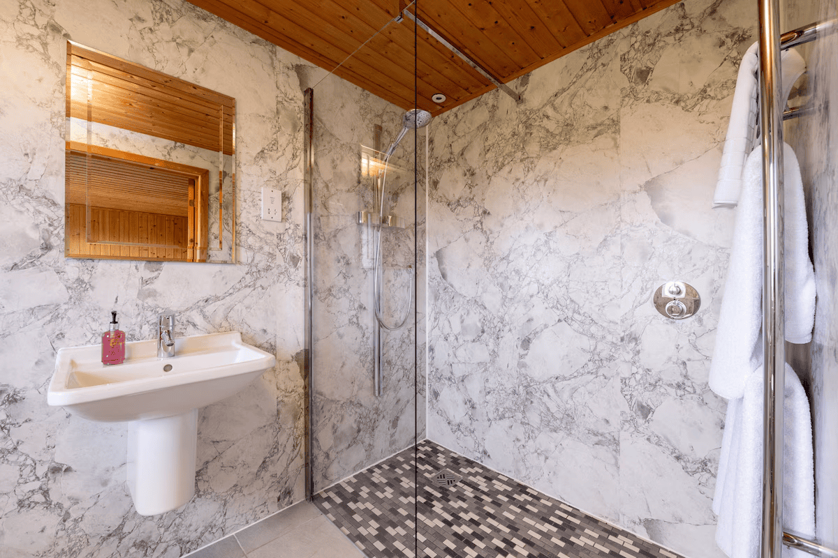 Modern bathroom with marble walls and wooden accents