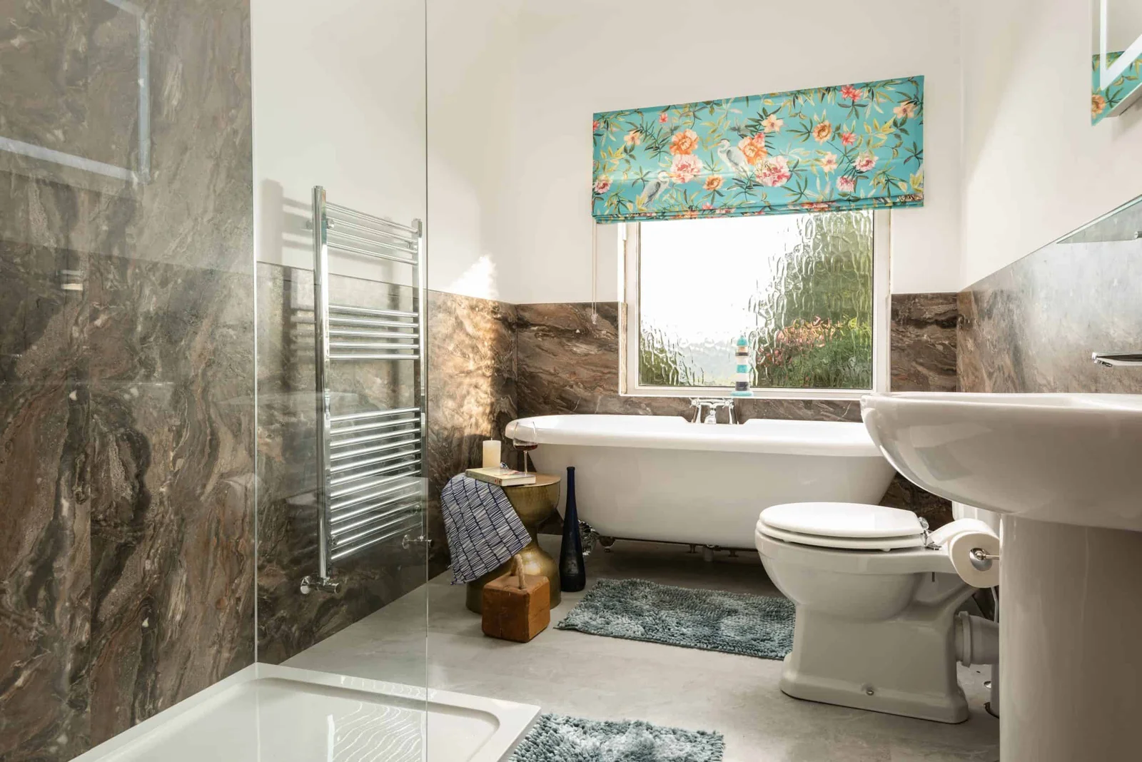 Modern bathroom with floral window treatment and stone walls