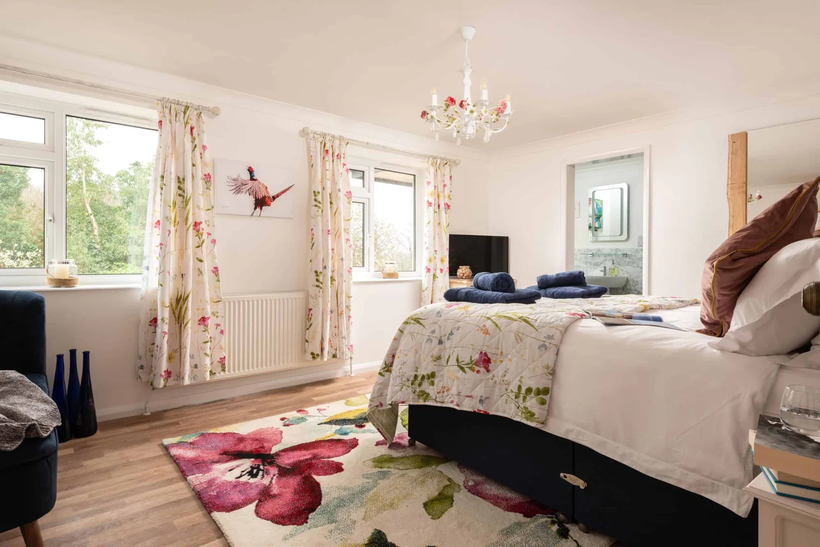 Bright bedroom with floral decor and lush green view