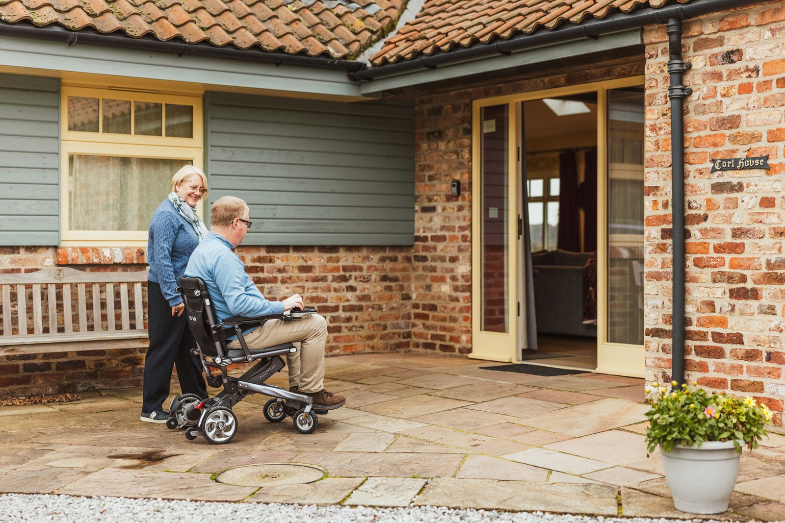 Man in wheelchair entering accessible home entrance.