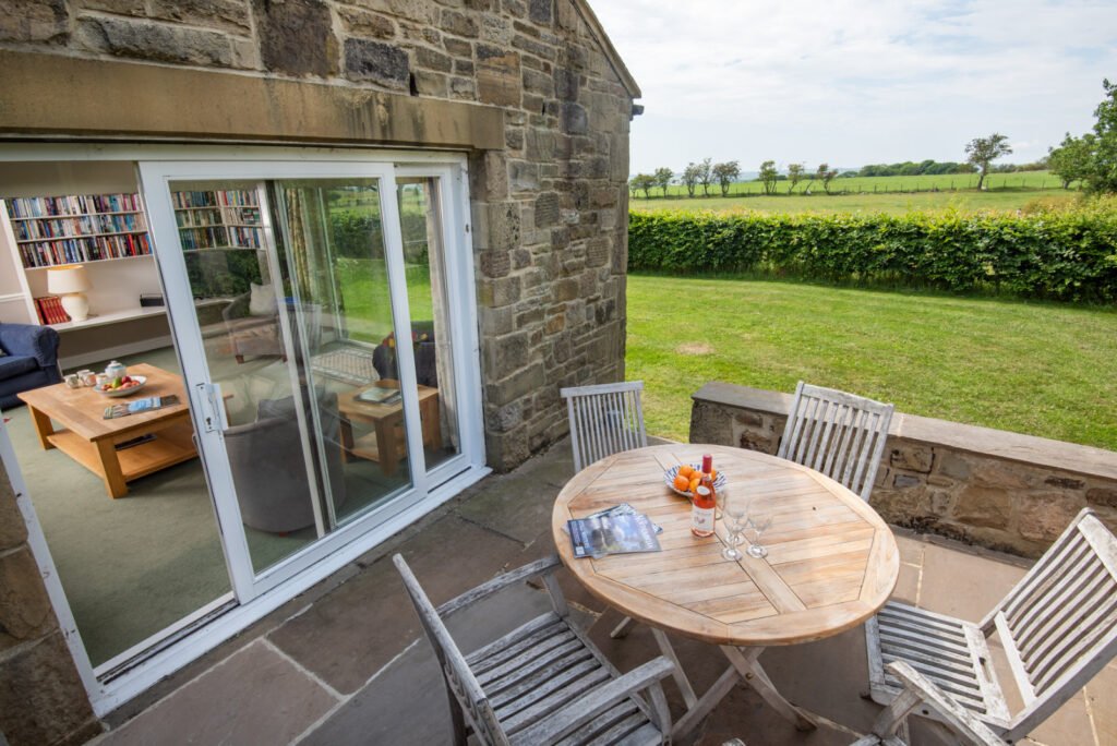 Stone patio with garden view and sliding glass door.