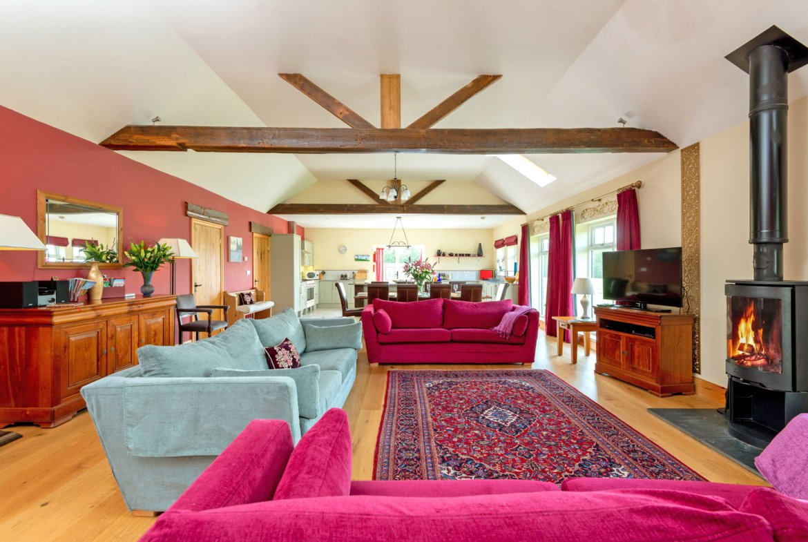 Spacious living room with red sofas and fireplace.
