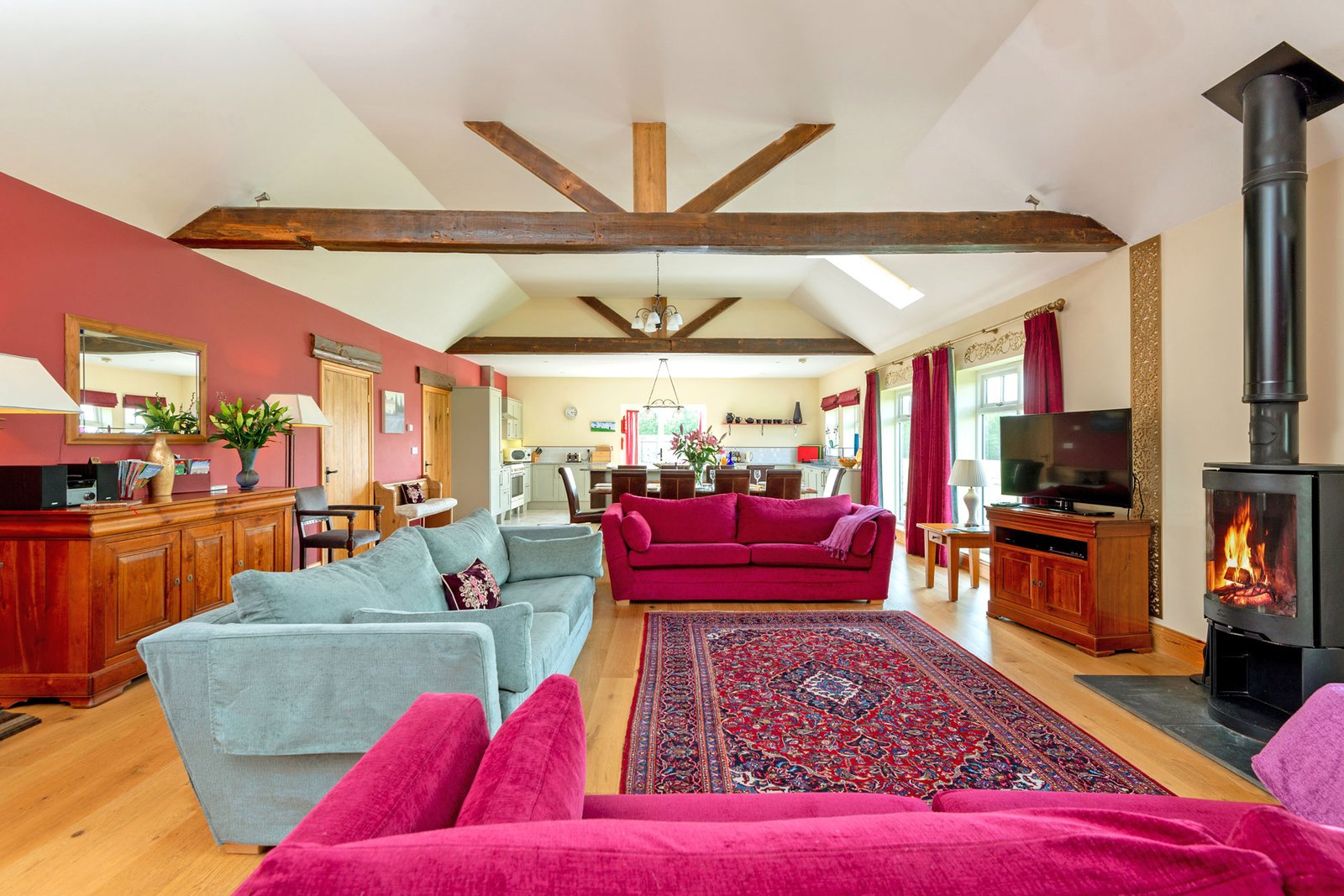 Spacious living room with red sofas and fireplace.
