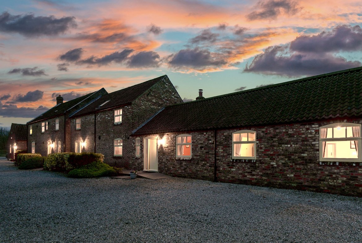 Cottage at sunset with illuminated windows