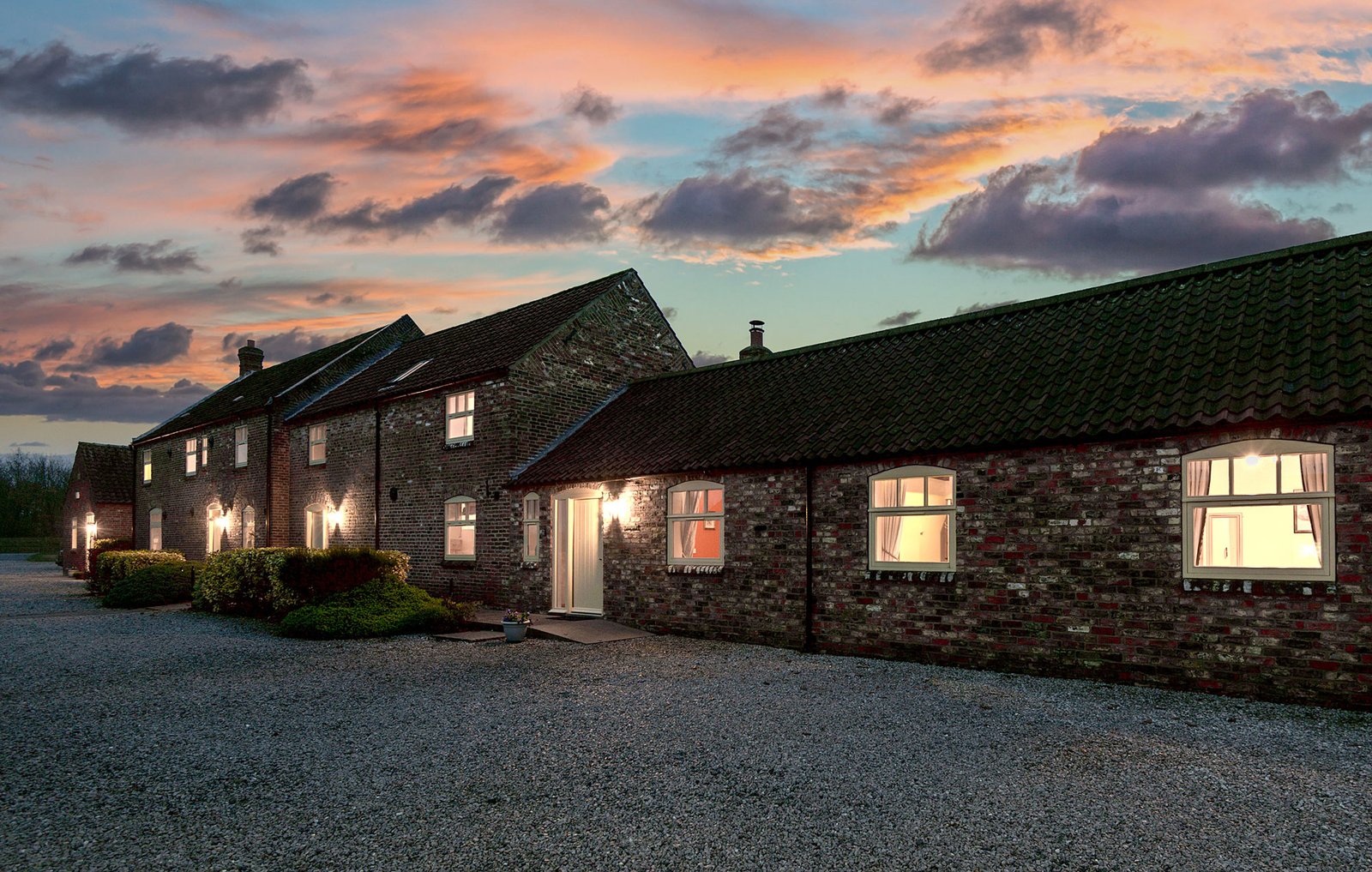 Cottage at sunset with illuminated windows