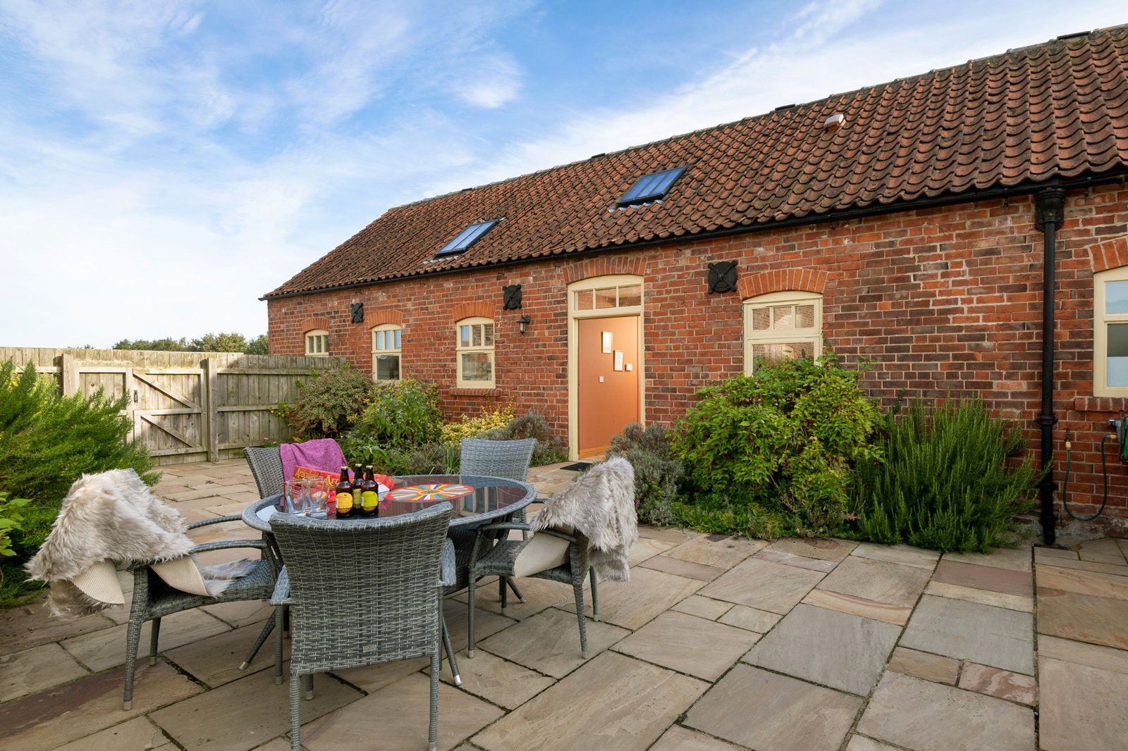 Charming brick cottage with outdoor patio furniture.