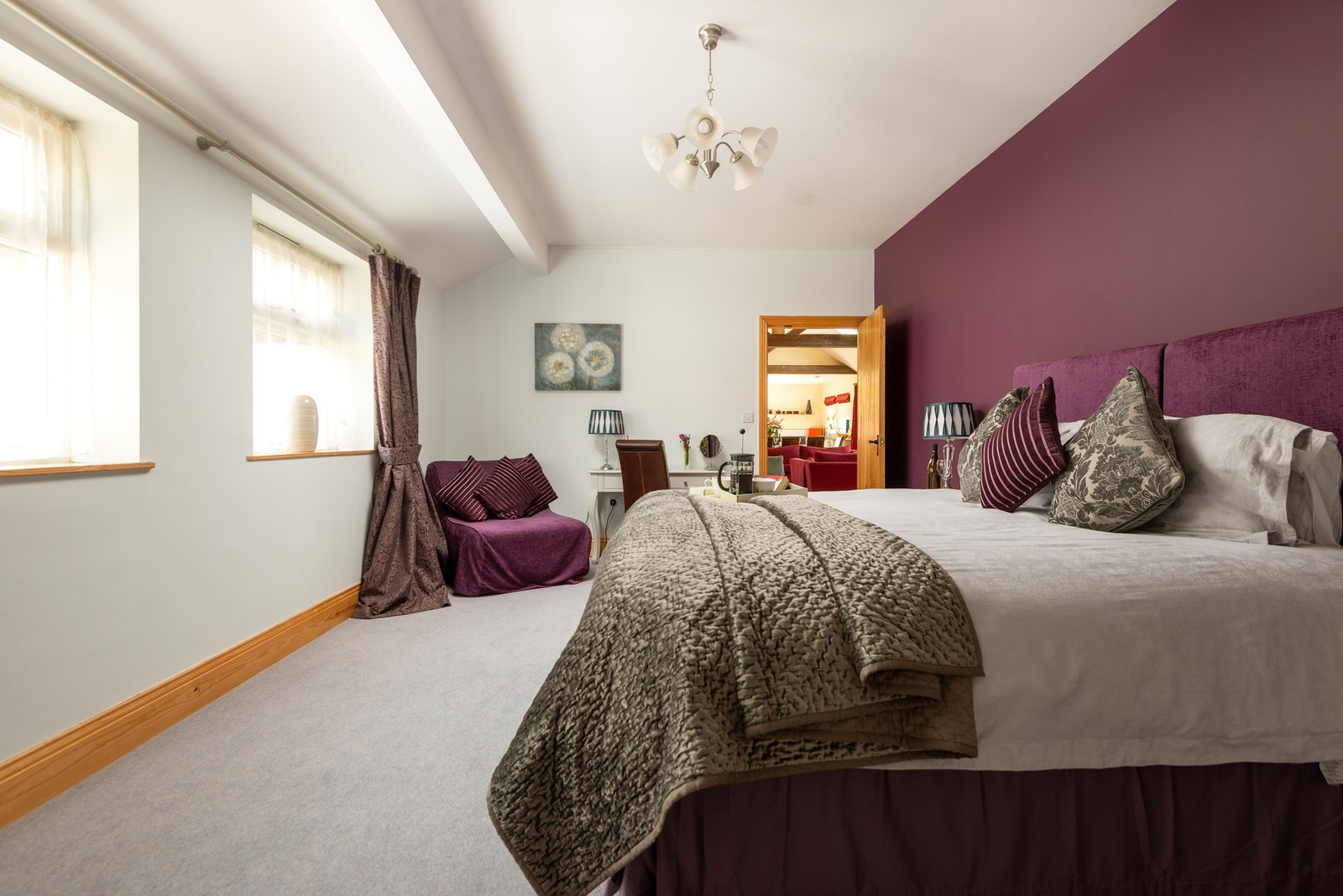 Spacious bedroom with purple accents and artwork.