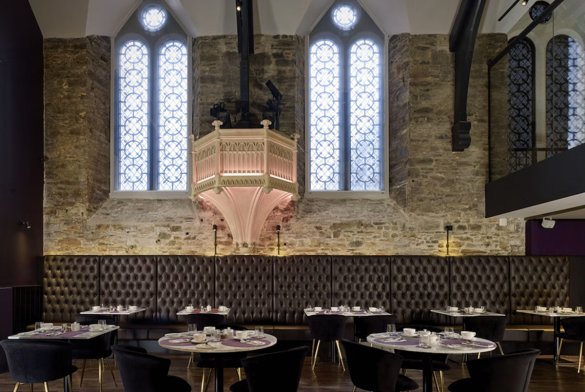 Chic restaurant in historic stone building with large windows.