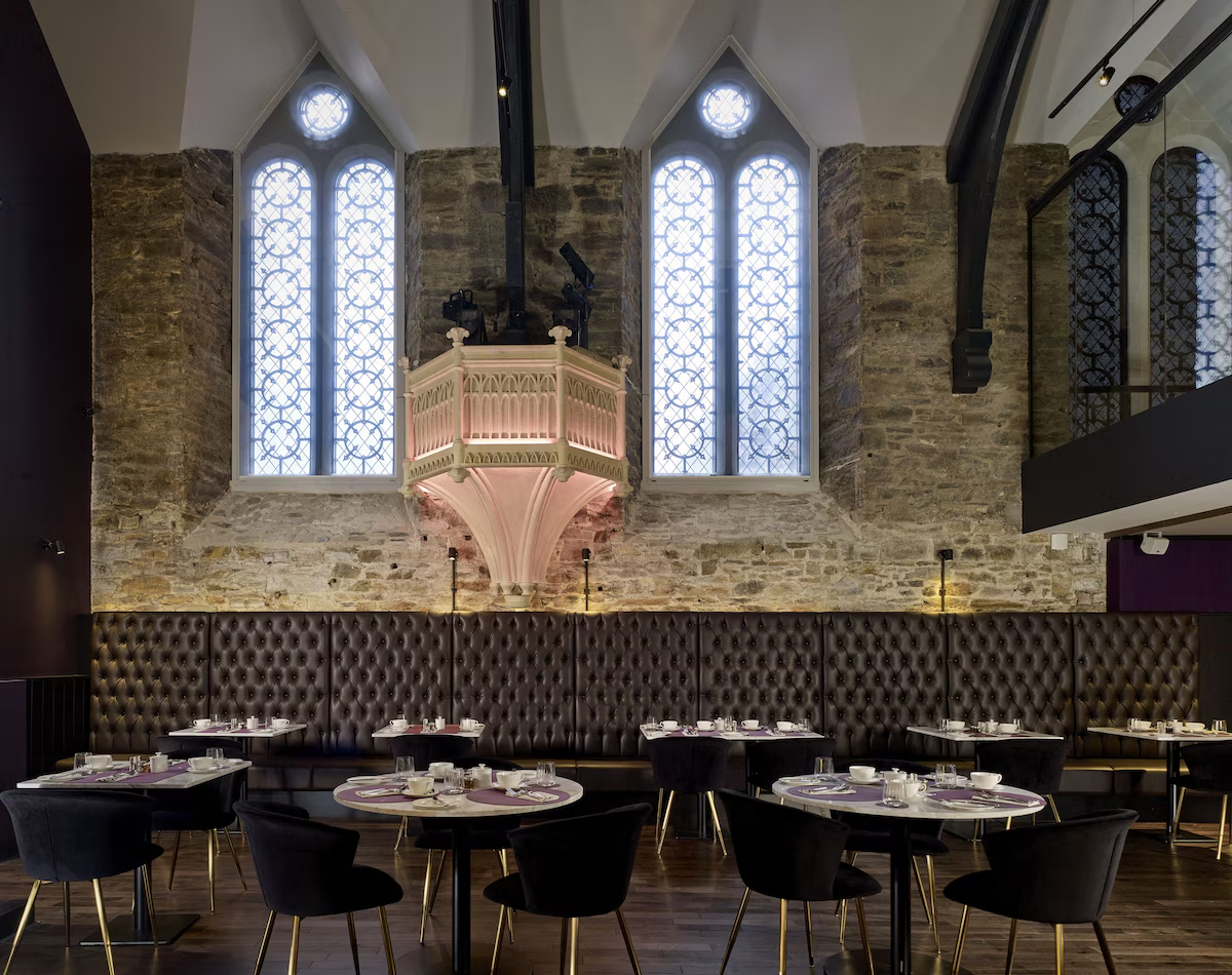Chic restaurant in historic stone building with large windows.