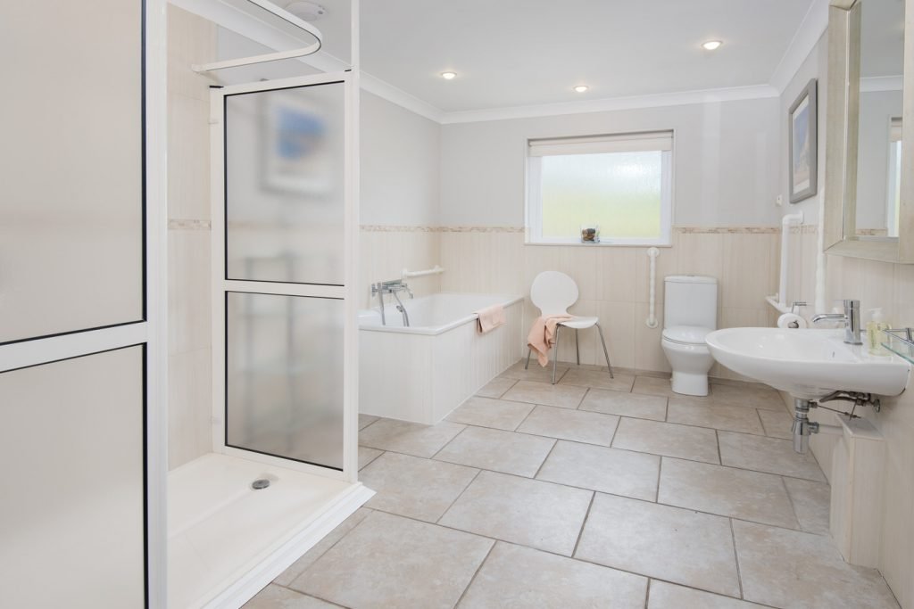 Modern bathroom with shower, bath, toilet, and sink.