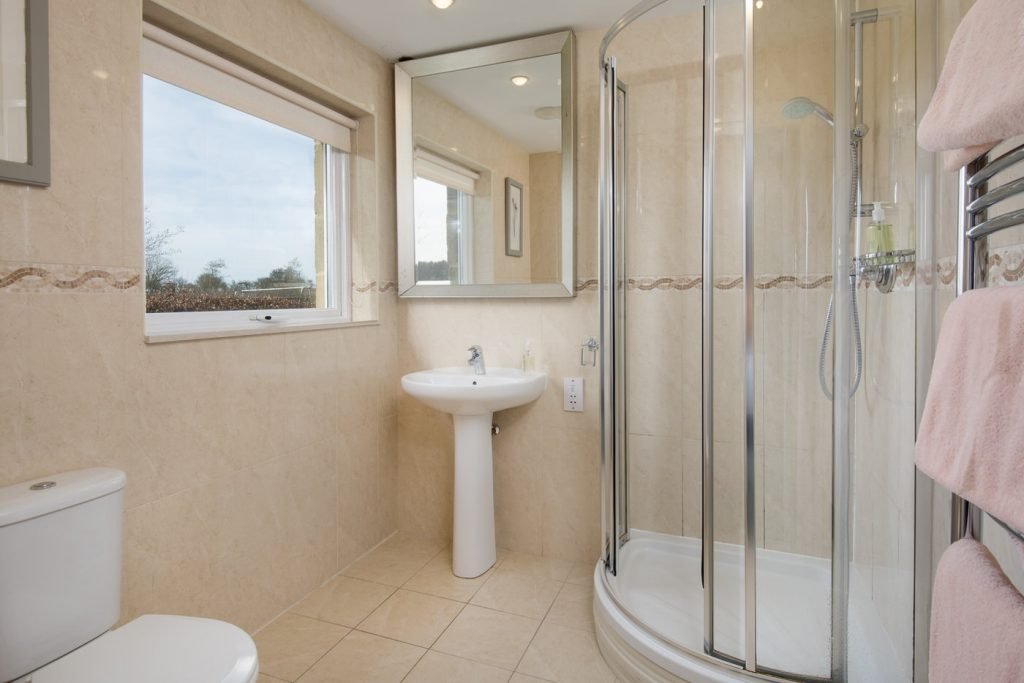 Modern bathroom with shower and large mirror.
