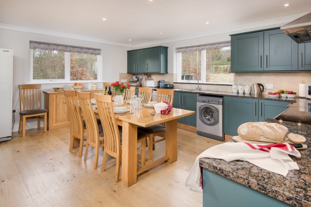 Spacious kitchen with dining table and wooden cabinets.
