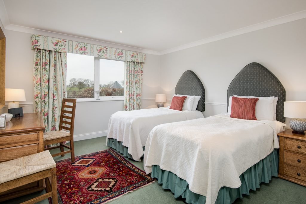 Cosy bedroom with two single beds and window view.