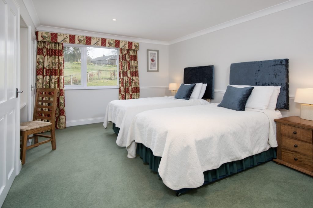 Cosy bedroom with two single beds and window.