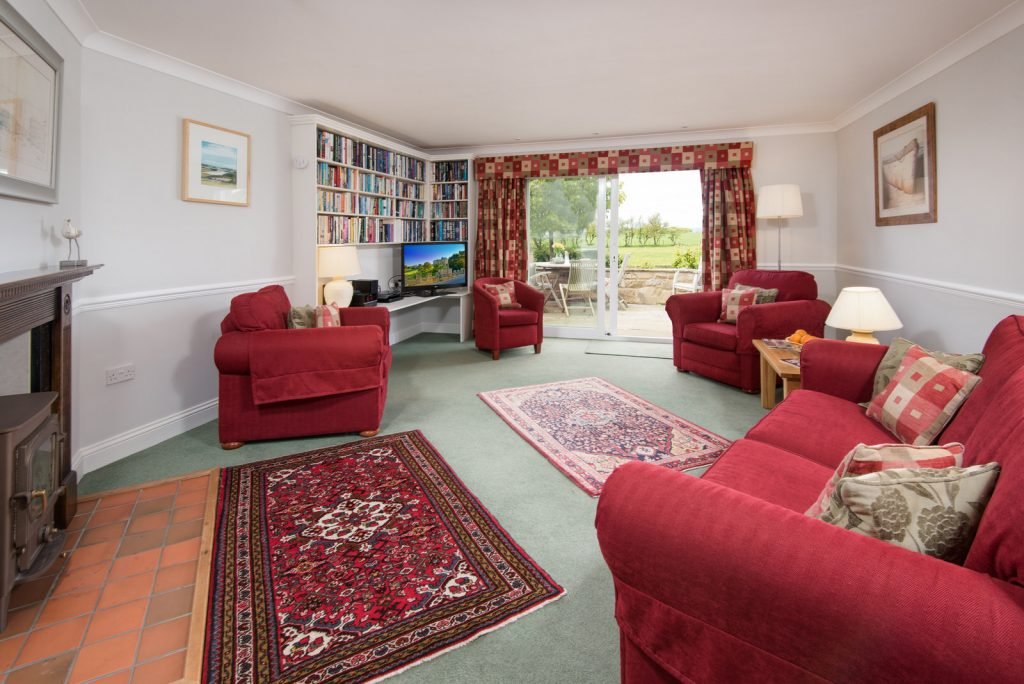 Cosy living room with red sofas and books.