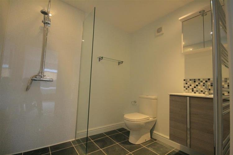 Modern bathroom with shower and tiled floor.