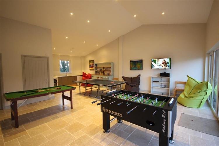 Modern games room with foosball, TV, and bean bags.