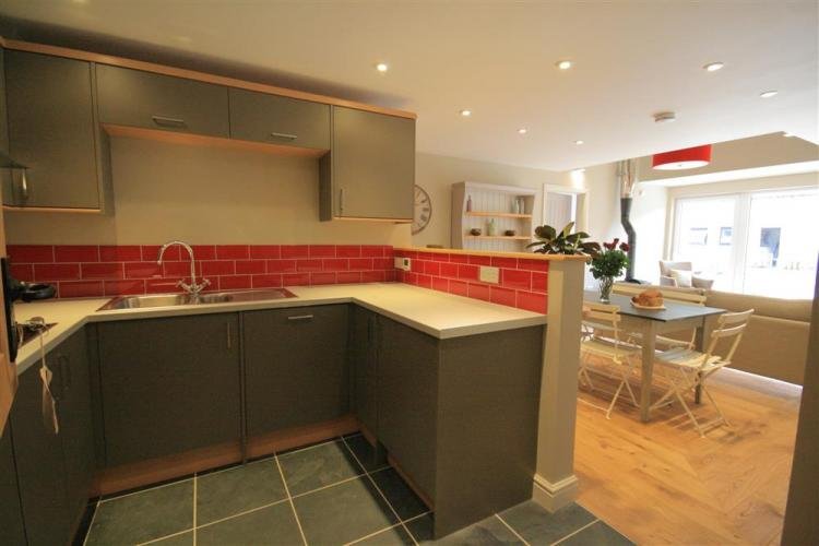 Modern kitchen and dining area with red tiles.